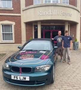 Justin and Jack with their Rust Bucket Rally car outside Randall & Payne office